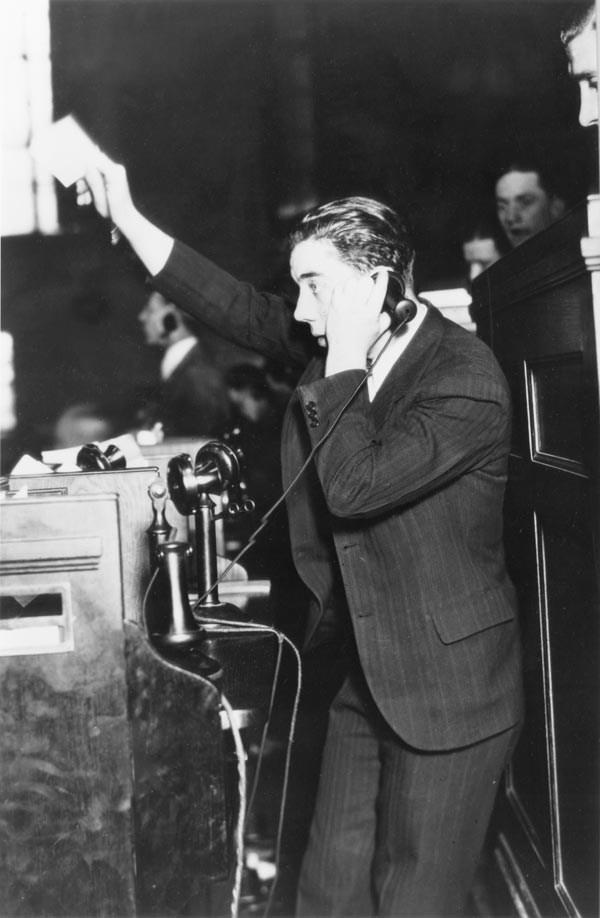 Trader in a suit on a telephone, holding up an order