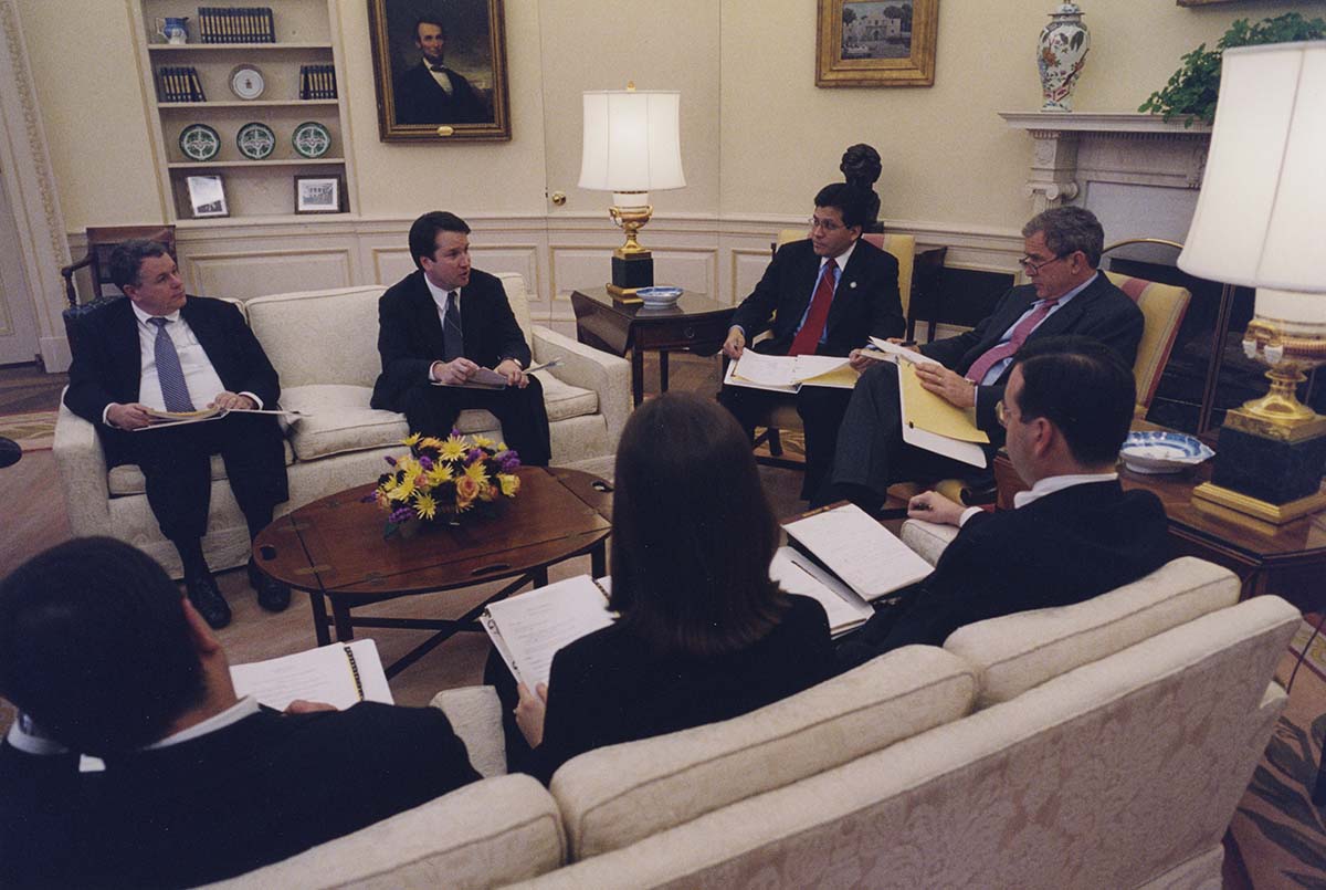 Group of staffers with President George Bush in the oval office seated on couches.