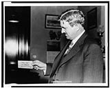 Senator Clarence Dill with one of the wooden dollars used in Tenino, Washington
