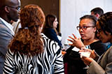 PCAOB's Tope Folarin (left) speaks with DePaul University Assistant Professor Stephani Mason (right)