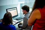 Georgia State University Investor Advocacy Clinic students Bryan Rafie and Kelly Robinson with Professor Nicole G Iannarone in a student work room. 